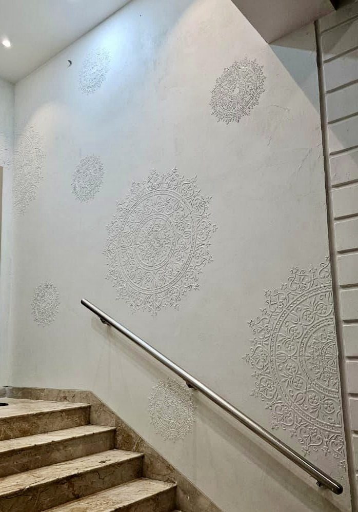 Textured plaster stairwell wall with repeating motif
