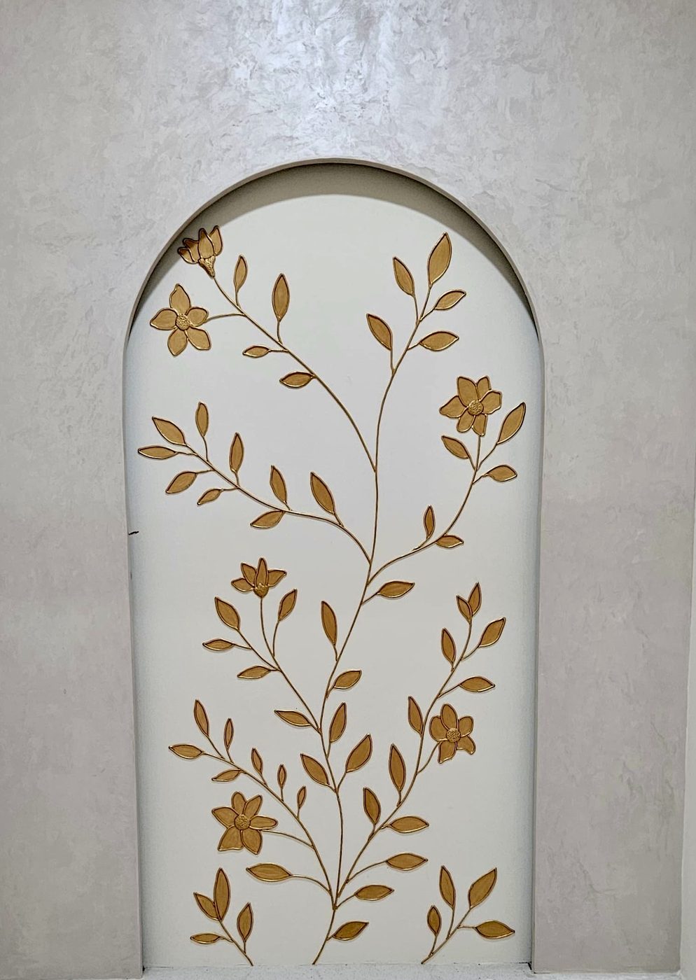 Gilded leaf and blossom motif inside an arched niche