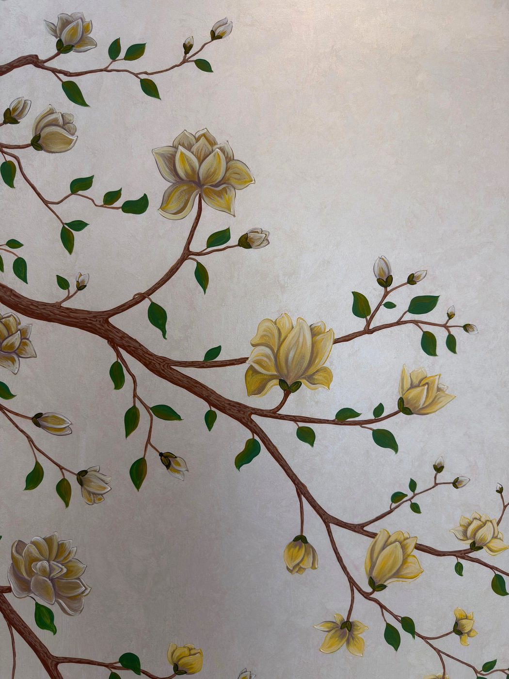 Magnolia branch detail painted across a wall